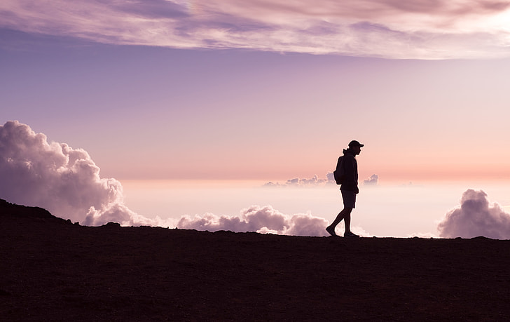 Person walking outdoors at sunset reflecting on building sustainable fitness habits