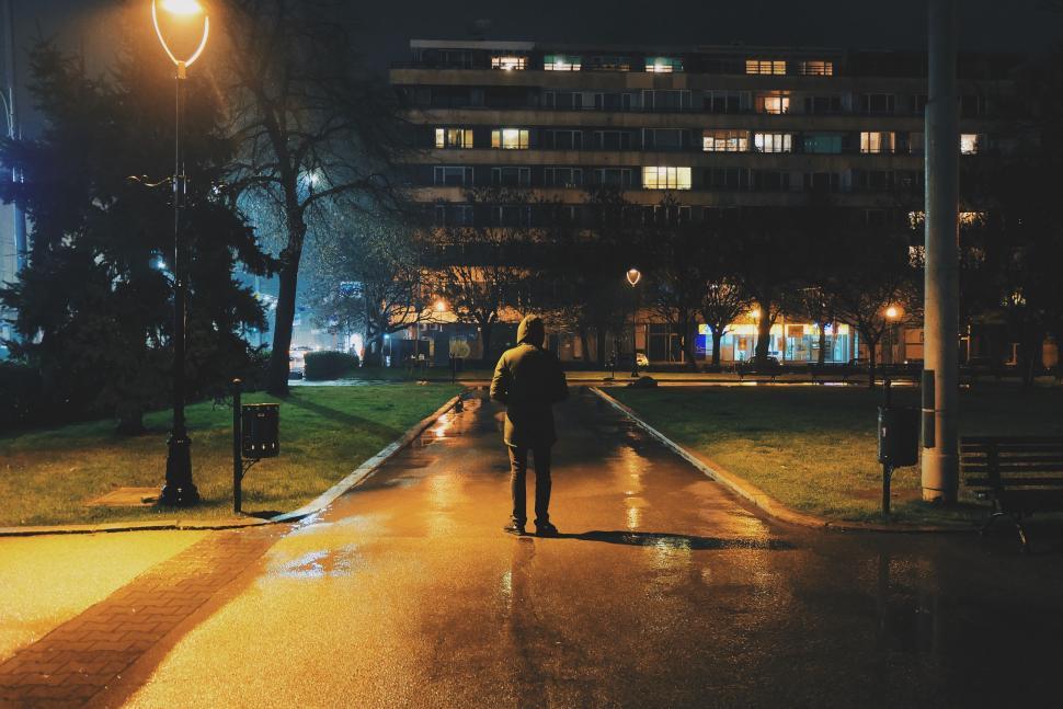 Side silhouette of someone jogging at dusk with city lights slightly blurred.