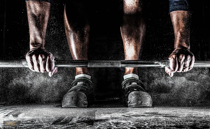 Close-up of hands gripping a heavy barbell during a lift