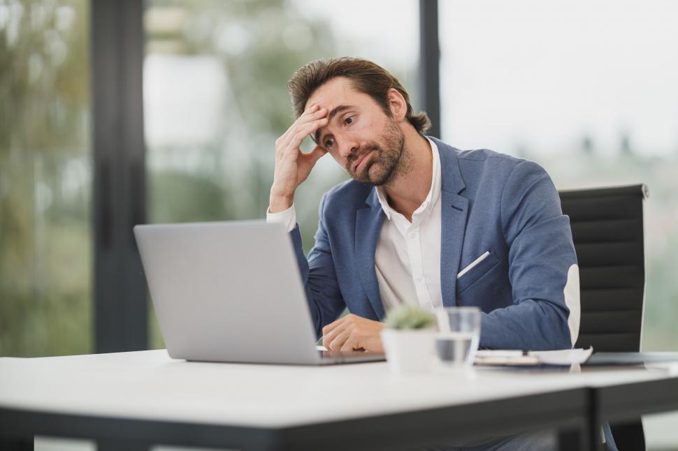 Tired man working late at desk showing mental fatigue impacting fitness performance
