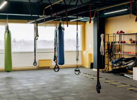 Empty gym in the early morning with soft natural light and a barbell set up on the floor