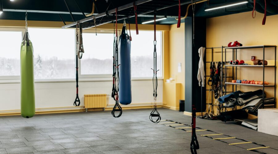 Empty gym in the early morning with soft natural light and a barbell set up on the floor