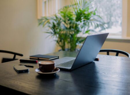 Person sitting alone at a desk in soft natural light, looking thoughtful and mentally fatigued.