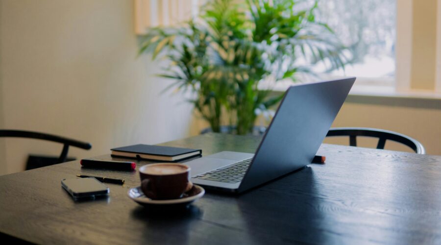 Person sitting alone at a desk in soft natural light, looking thoughtful and mentally fatigued.
