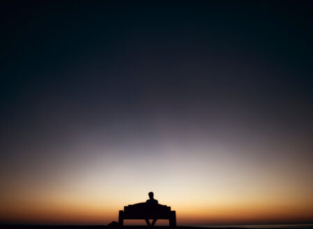 “Man sitting quietly at dawn reflecting before starting his day”