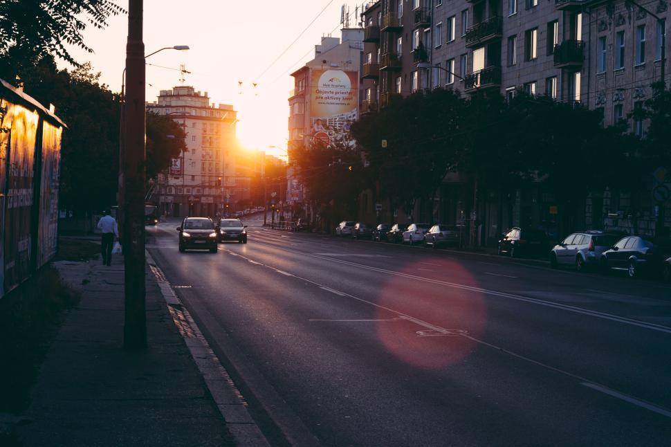 Quiet city street at sunrise with soft morning light and empty road
