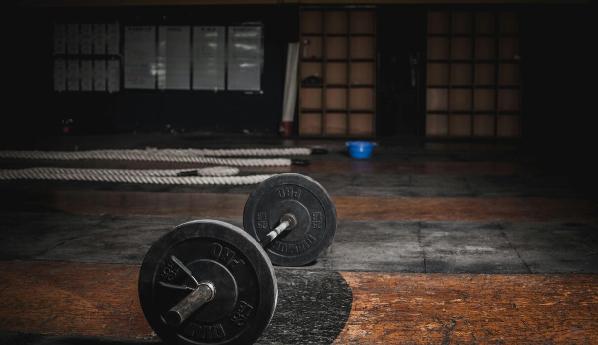 Empty gym early morning with barbell on the floor before workout