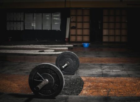 Empty gym early morning with barbell on the floor before workout