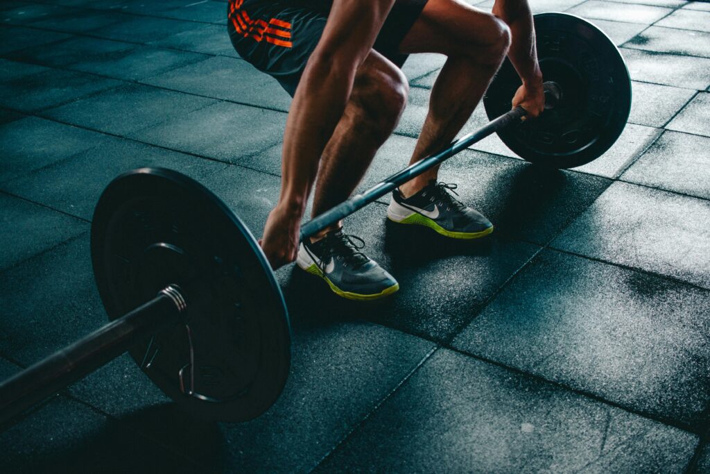 person holding barbell showing the beginning Close-up of hands gripping a barbell with chalk