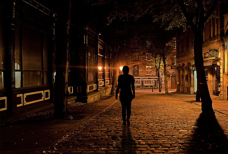 Person walking alone at night symbolizing quiet discipline and persistence