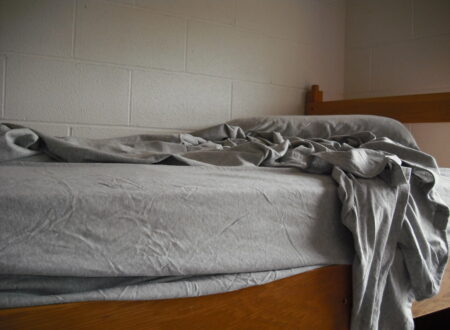 Unmade bed with early morning light symbolizing the struggle to get up for training