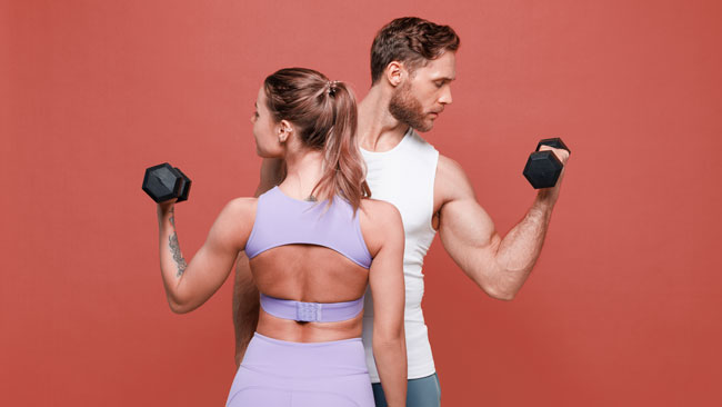 Beginner lifting weights in gym performing compound exercise for muscle growth