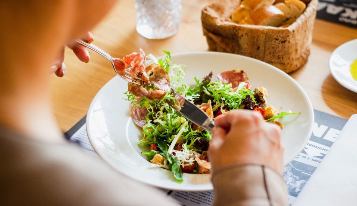 person planning daily protein intake with high protein foods for muscle building