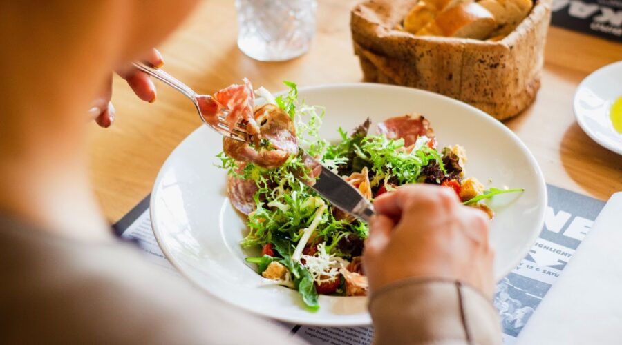 person planning daily protein intake with high protein foods for muscle building