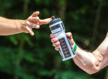 person drinking water from a bottle after workout showing hydration and fitness lifestyle