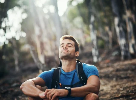 person sitting calmly with eyes closed practicing breathing while looking relaxed
