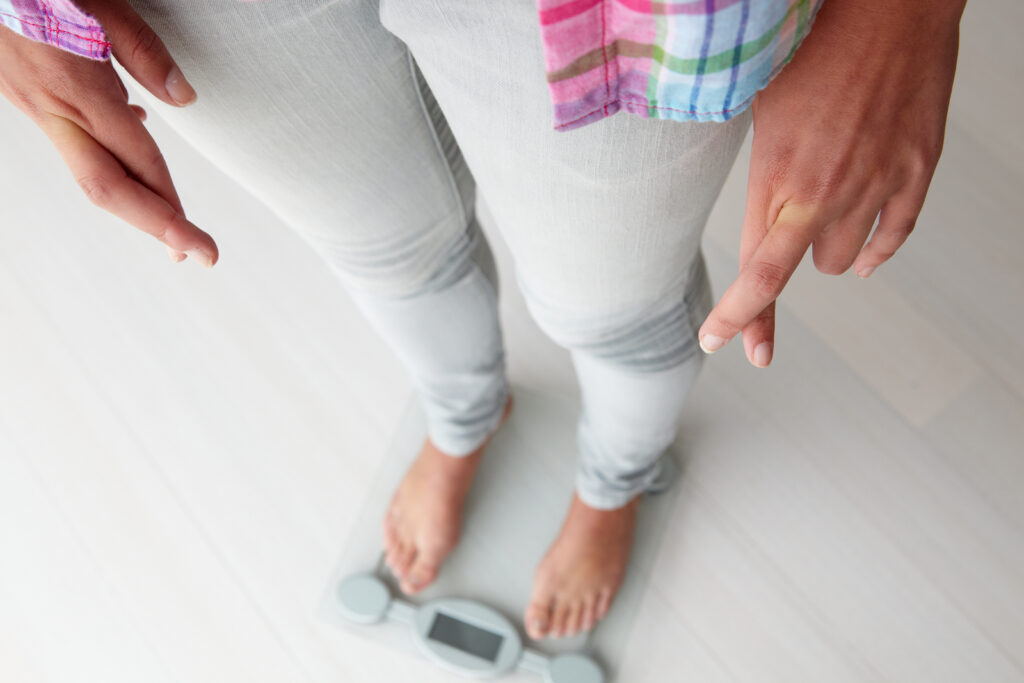 What Losing Weight on the Scale Really Means Close-up of weighing scale showing body weight measurement